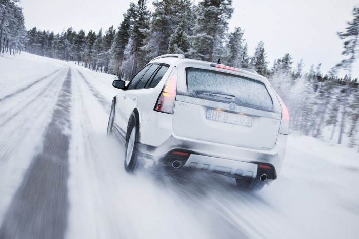 White car driving on snowy road