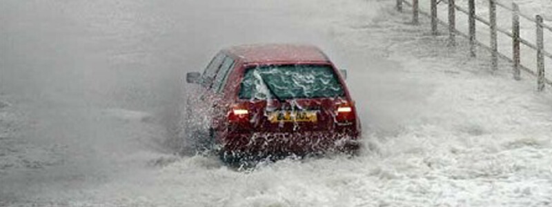 Red car driving through a lot of water