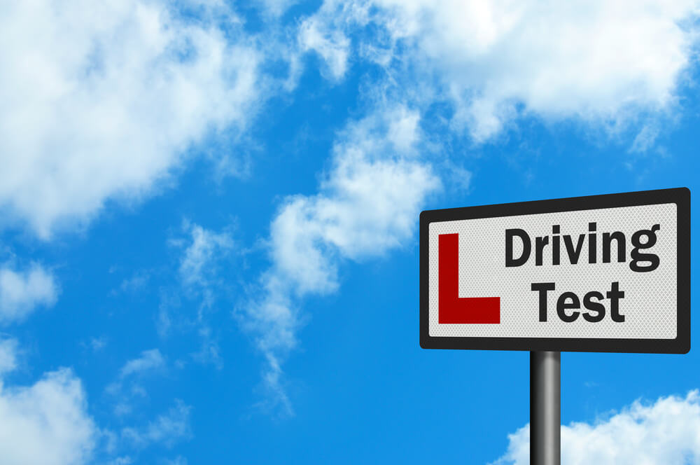 Driving test sign against blue sky