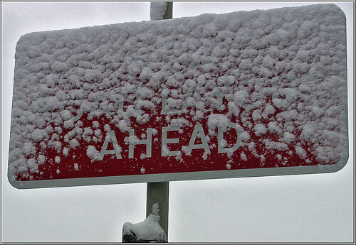 Red road sign covered with snow