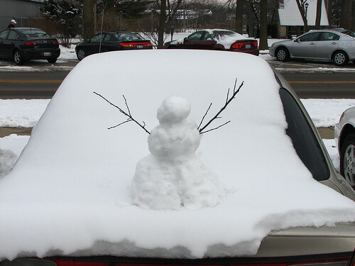 Snowman on bonnet of car